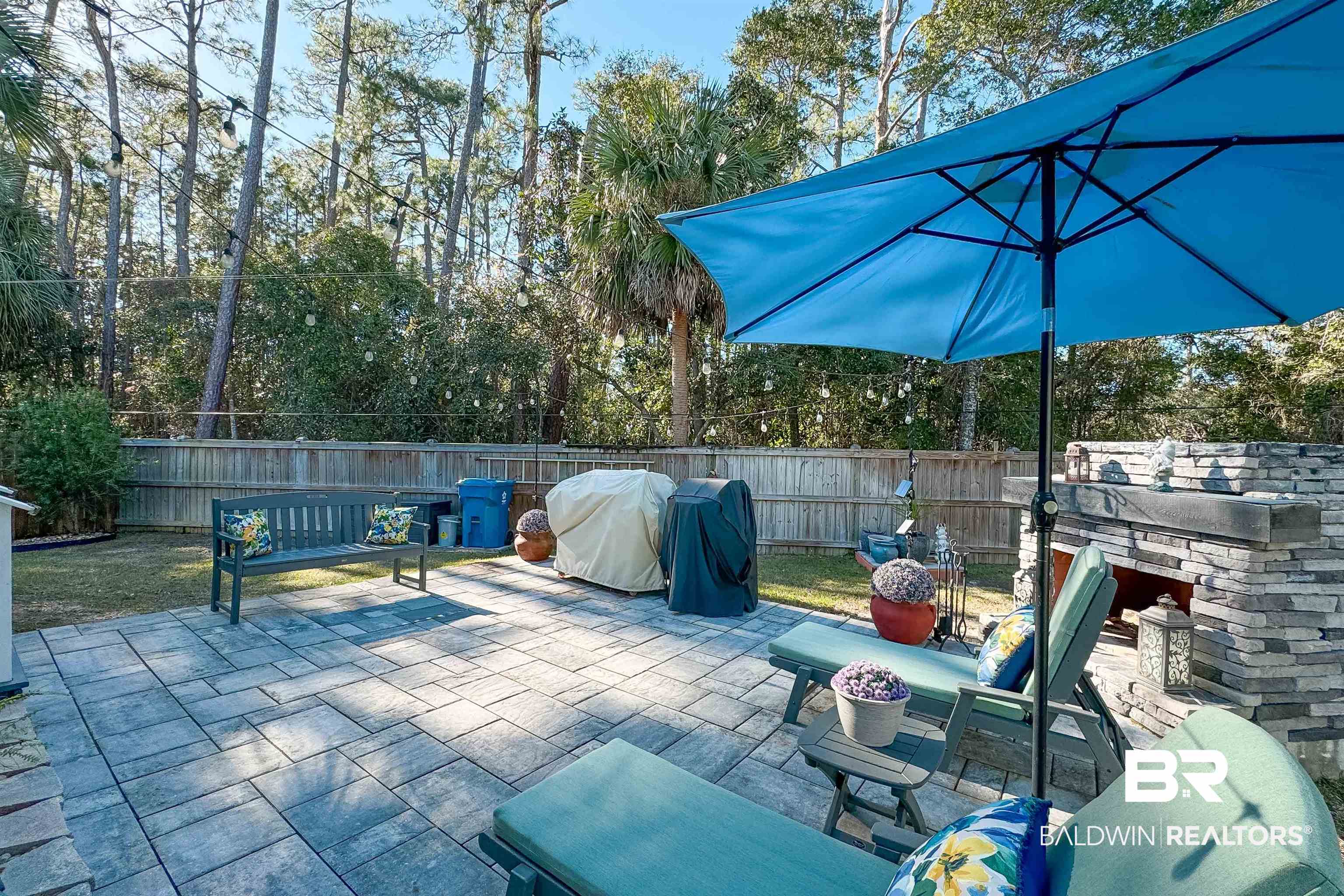 1290 Mako Loop Gulf Shores, AL 36542 - Photo 39 of 50 View of patio / terrace featuring an outdoor stone fireplace, a fenced backyard, and grilling area