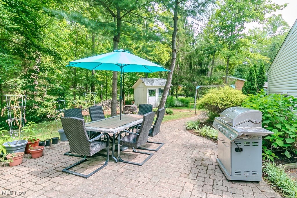 33 Woodside Road Chagrin Falls, OH 44022 - Photo 45 of 48 View of patio / terrace with outdoor dining space, area for grilling, a storage shed, and view of scattered trees