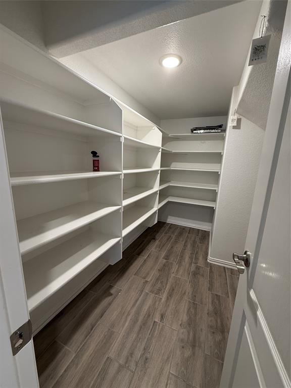 5212 Troupe Road McKinney, TX 75071 - Photo 10 of 38 Expansive pantry featuring extensive built-in shelving, recessed ceiling lighting, and wood-finish tile flooring