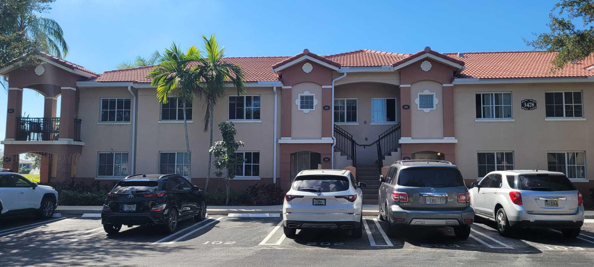 3478 Briar Bay Boulevard, Unit 202 West Palm Beach, FL 33411 - Photo 17 of 23 a front view of a house with parking space