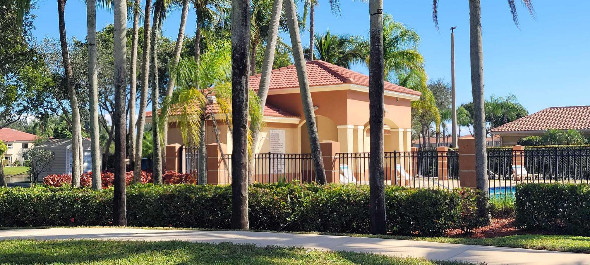 3478 Briar Bay Boulevard, Unit 202 West Palm Beach, FL 33411 - Photo 2 of 23 a view of a palm trees in front of a building