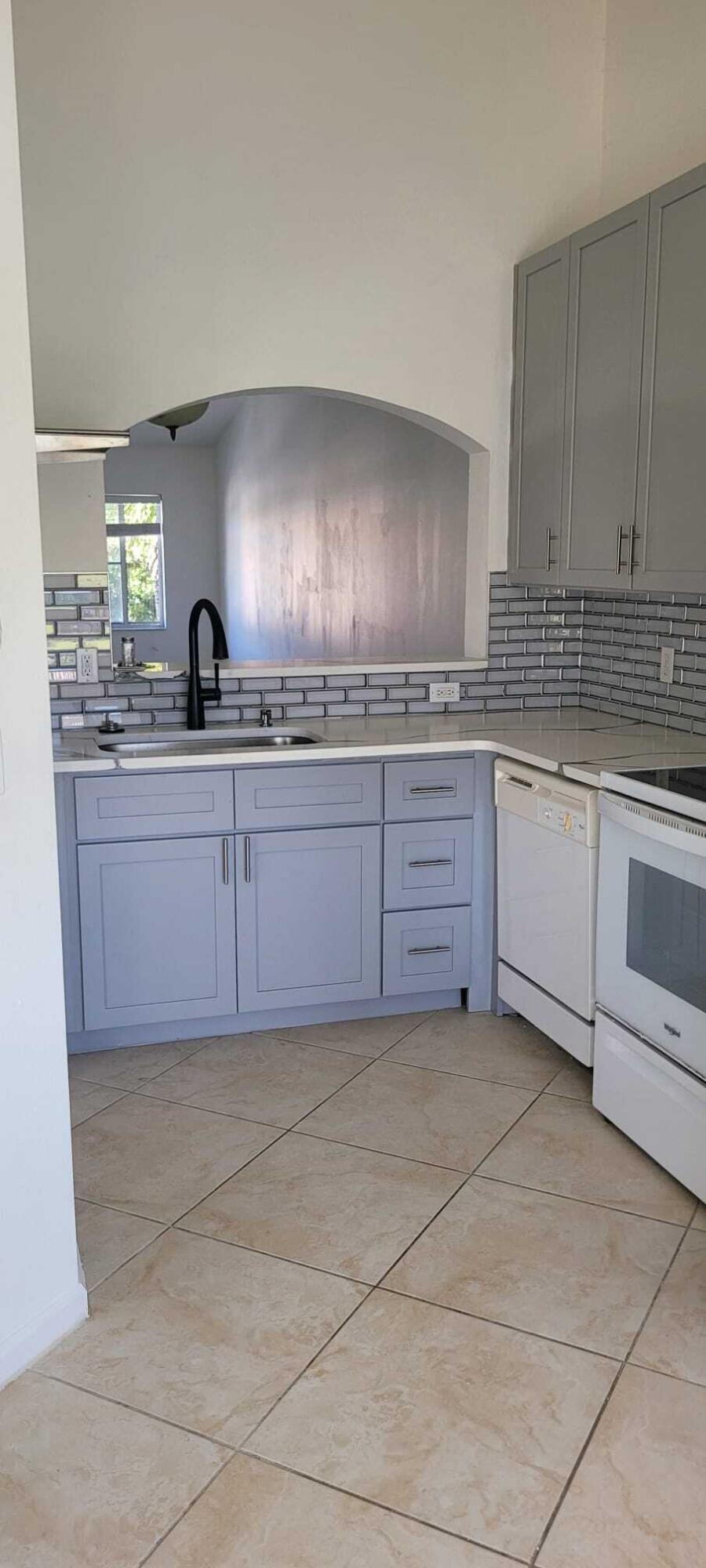 3478 Briar Bay Boulevard, Unit 202 West Palm Beach, FL 33411 - Photo 4 of 23 a kitchen with granite countertop a sink and cabinets