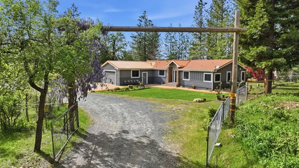 a aerial view of a house with yard and tree s