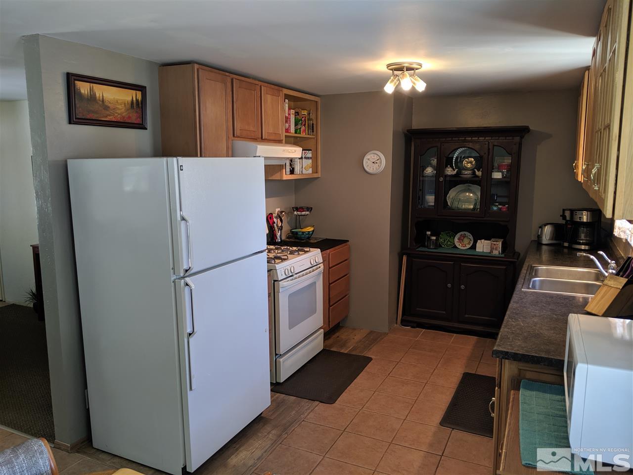 9290 Fremont Way Reno, NV 89506 - Photo 4 of 18 a white refrigerator freezer and a stove sitting inside of a kitchen