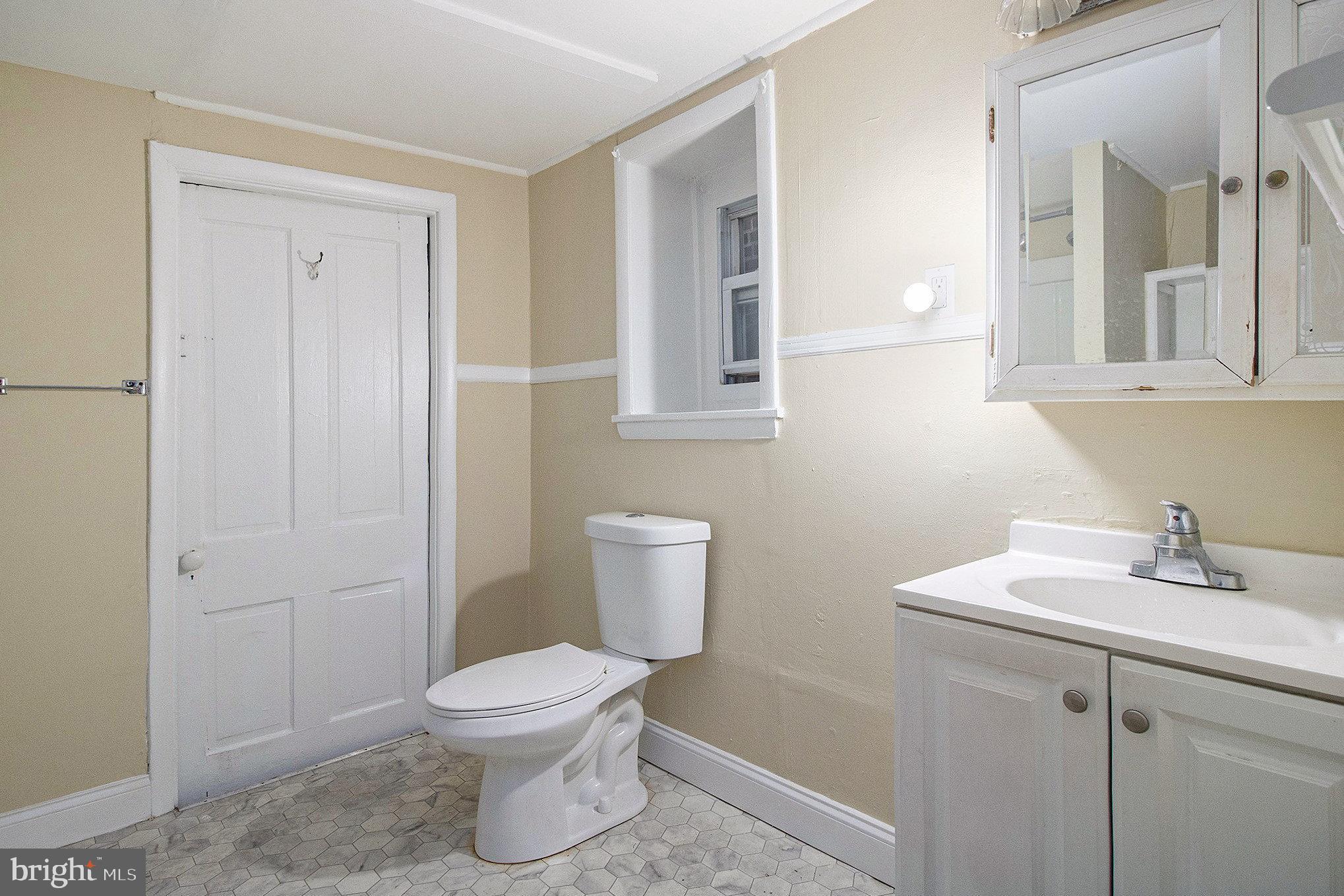 809 George Street Norristown, PA 19401 - Photo 14 of 24 a bathroom with a toilet a sink and mirror