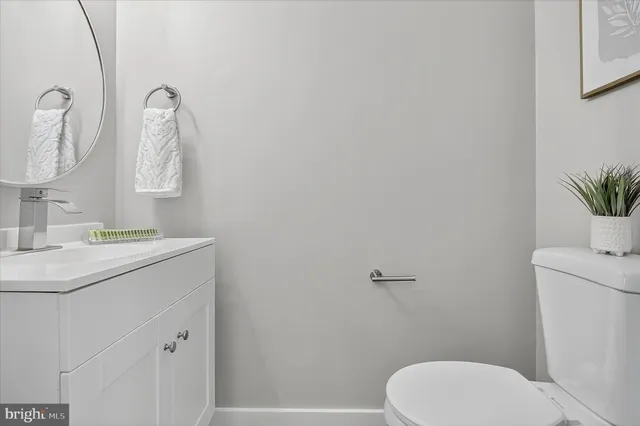 a bathroom with a toilet sink vanity and mirror