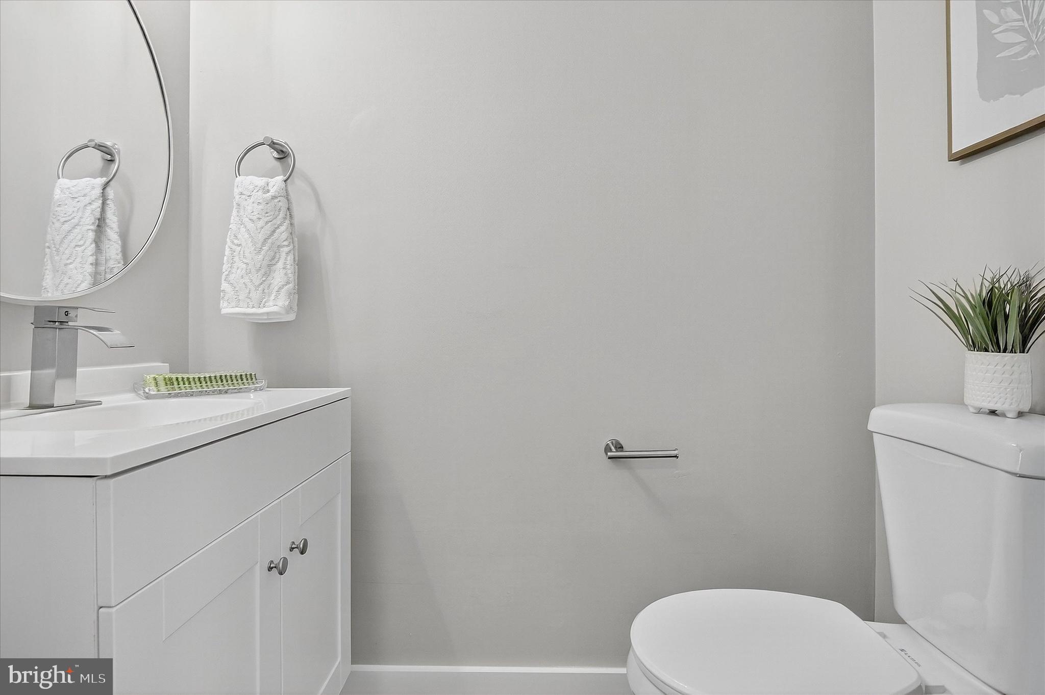 3681 Masthead Trail Triangle, VA 22172 - Photo 16 of 40 a bathroom with a toilet sink vanity and mirror