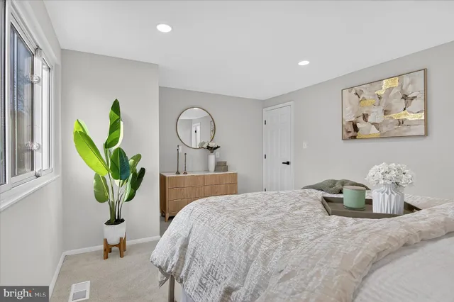 a bedroom with a bed and painting on the wall