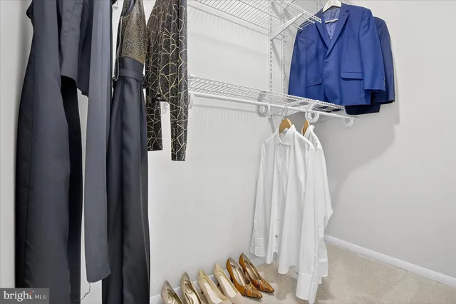 a view of walk in closet with clothes