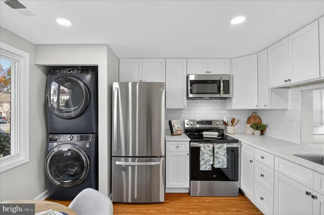 a kitchen with a refrigerator a stove top oven a sink and cabinets