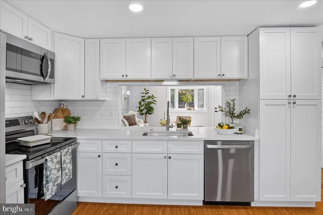 a kitchen with white cabinets and appliances