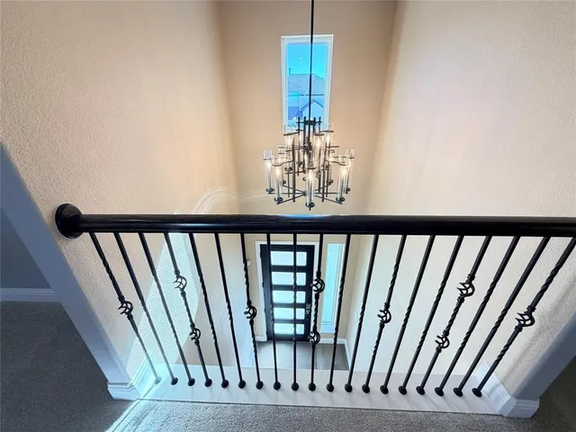 a view of staircase with lots of frames on wall and wooden floor