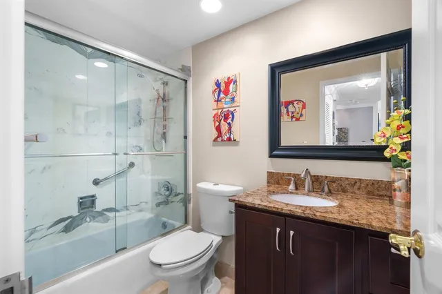 a bathroom with a granite countertop sink toilet and shower