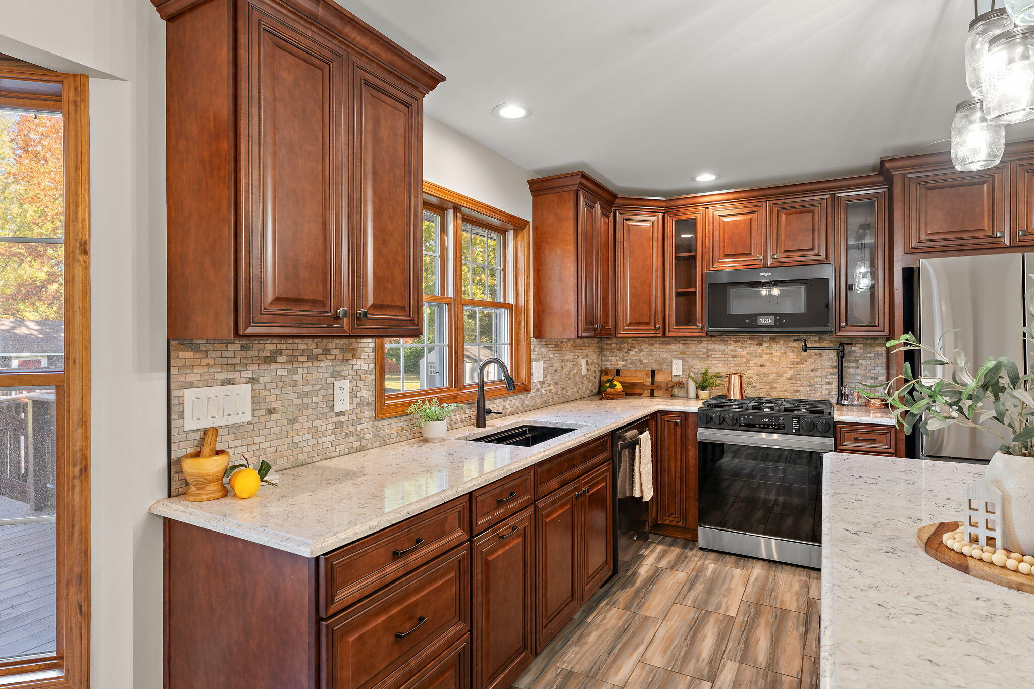 375 Reif Drive Hebron, IN 46341 - Photo 19 of 58 a kitchen with a sink a stove cabinets and a wooden floor