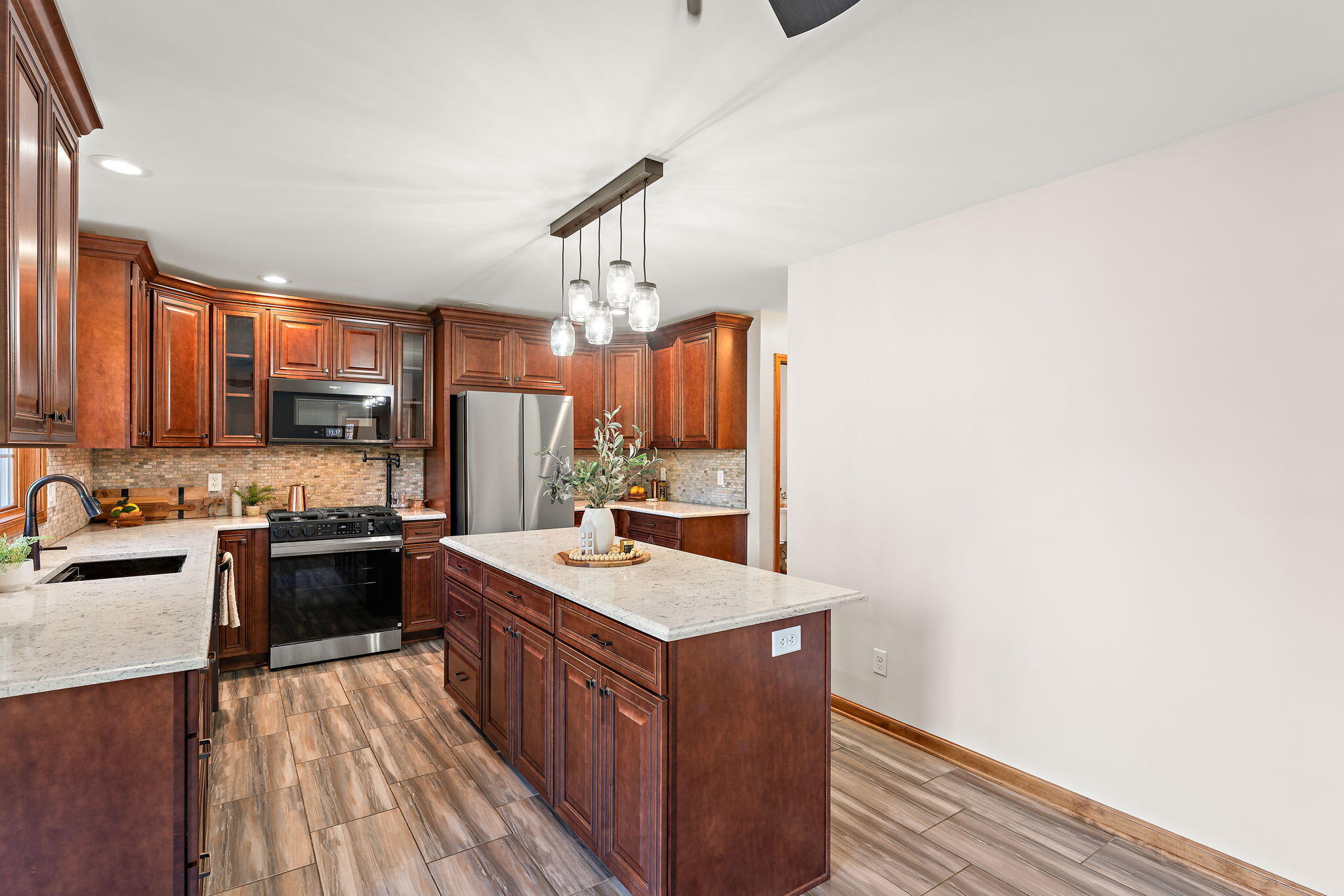 375 Reif Drive Hebron, IN 46341 - Photo 20 of 58 a large kitchen with a stove a sink dishwasher and a refrigerator with wooden floor