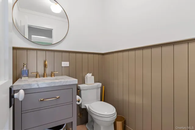 a bathroom with a toilet a sink and a mirror