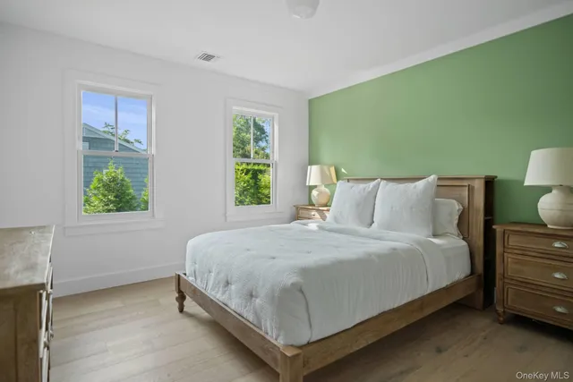 a large bed sitting in a bedroom next to a window