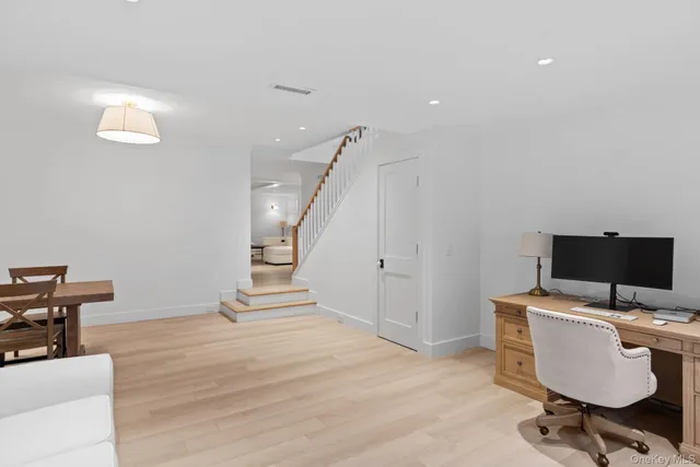 a view of a workspace with furniture and wooden floor