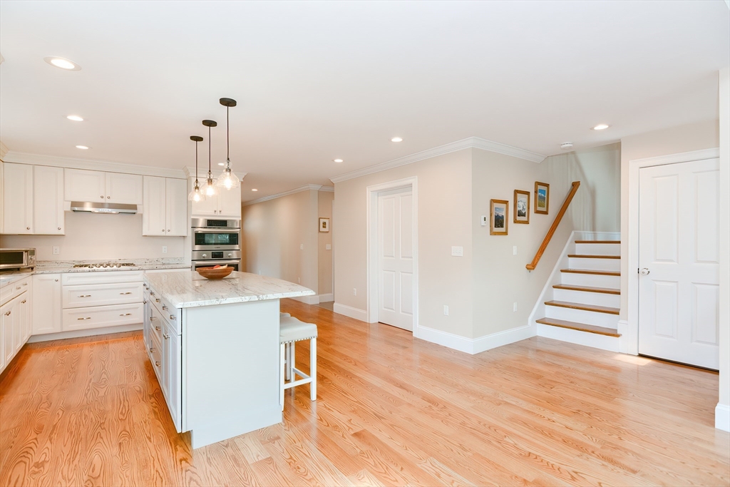 29 Webb Place, Unit A Mansfield, MA 02048 - Photo 11 of 42 a kitchen with granite countertop a stove top oven a sink dishwasher and a refrigerator with wooden floor