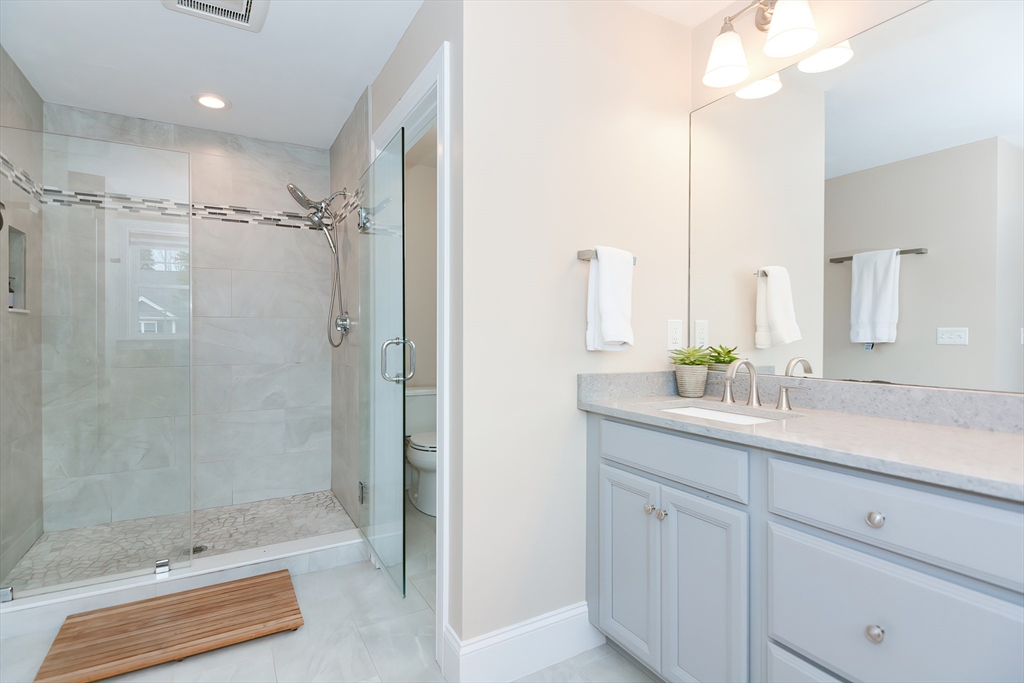 29 Webb Place, Unit A Mansfield, MA 02048 - Photo 29 of 42 a bathroom with a double vanity sink and mirror with shower