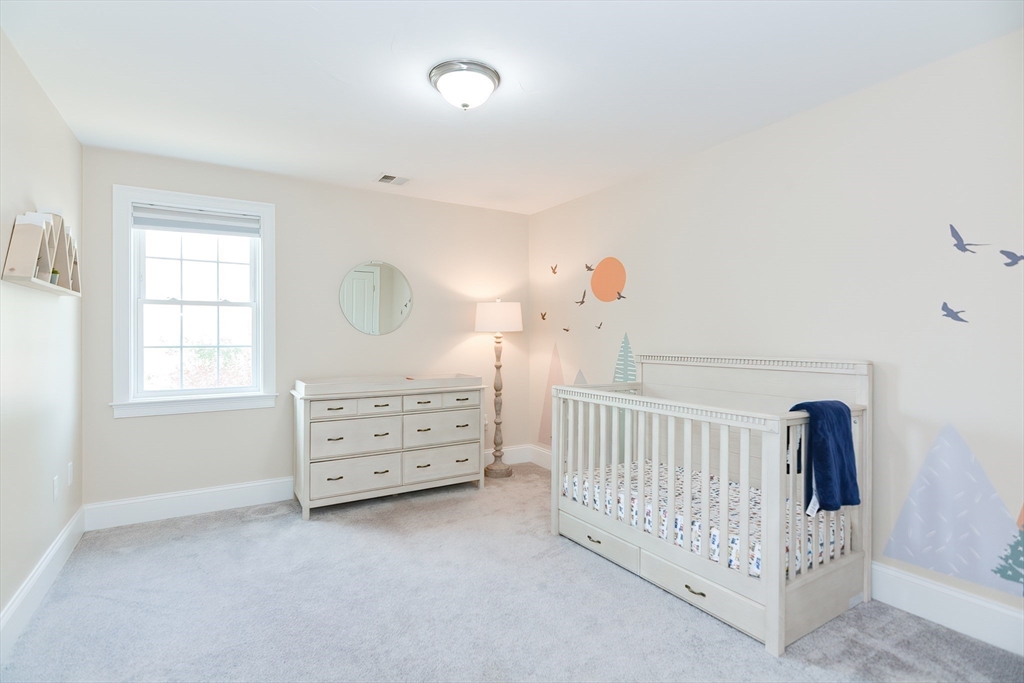 29 Webb Place, Unit A Mansfield, MA 02048 - Photo 33 of 42 a view of a bedroom with baby crib and a window
