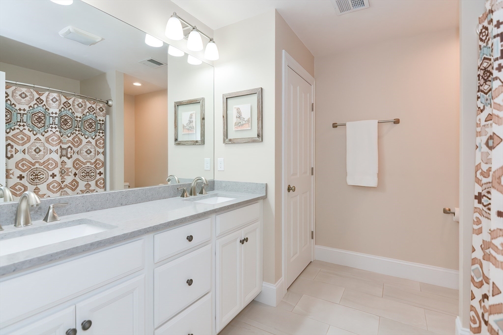 29 Webb Place, Unit A Mansfield, MA 02048 - Photo 34 of 42 a bathroom with a double vanity sink a mirror and a shower