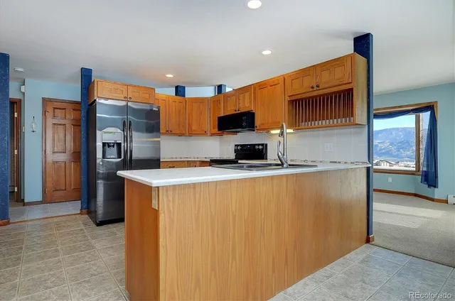a kitchen with stainless steel appliances granite countertop a refrigerator a stove and a sink