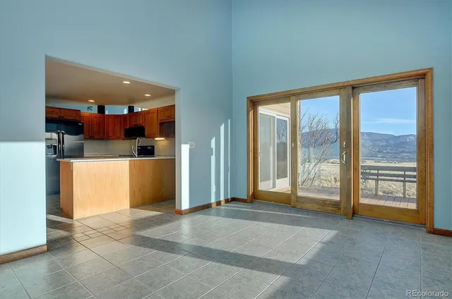 a view of kitchen with refrigerator and more cabinets