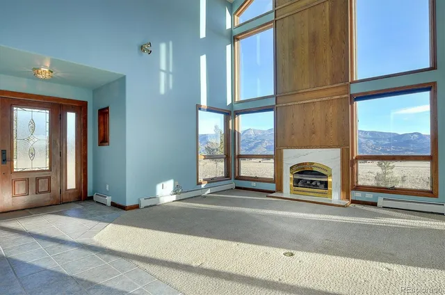 a living room with a fireplace furniture and a large window