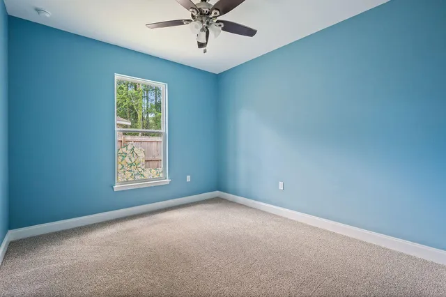 an empty room with closet and a ceiling fan