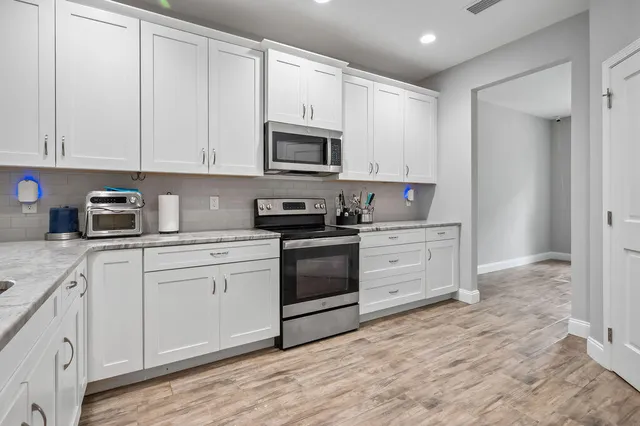 a kitchen with stainless steel appliances granite countertop a stove a sink and a refrigerator