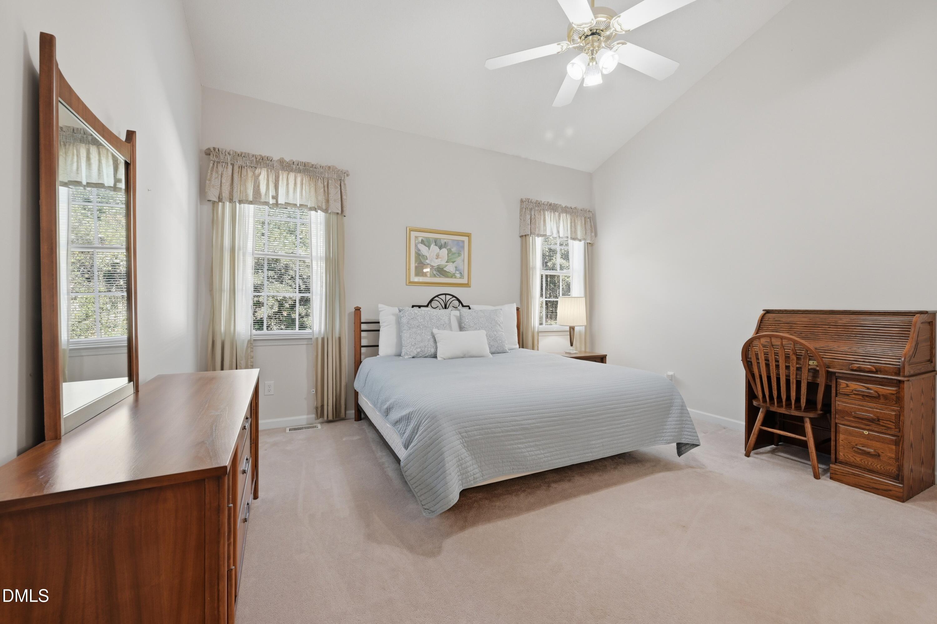 6801 Lynnoak Drive Raleigh, NC 27613 - Photo 15 of 30 a bedroom with a bed and a chandelier