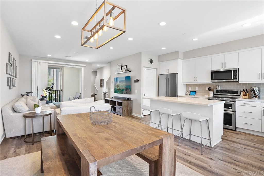 237 Magnet Irvine, CA 92618 - Photo 1 of 22 a kitchen with stainless steel appliances granite countertop a stove top oven a sink dishwasher a dining table and chairs with wooden floor