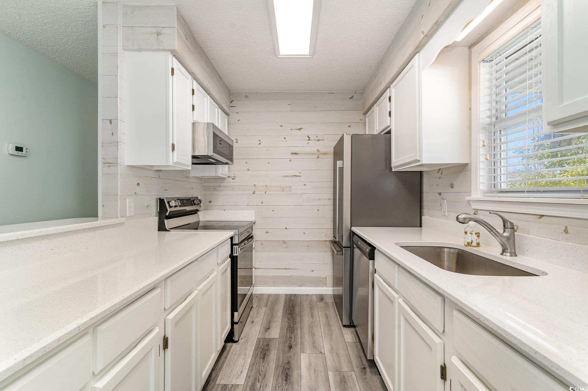 813 Starboard Court Murrells Inlet, SC 29576 - Photo 5 of 17 Kitchen featuring wooden walls, white cabinetry, s