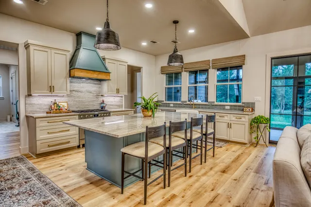 a kitchen with stainless steel appliances kitchen island granite countertop a stove a sink and a refrigerator