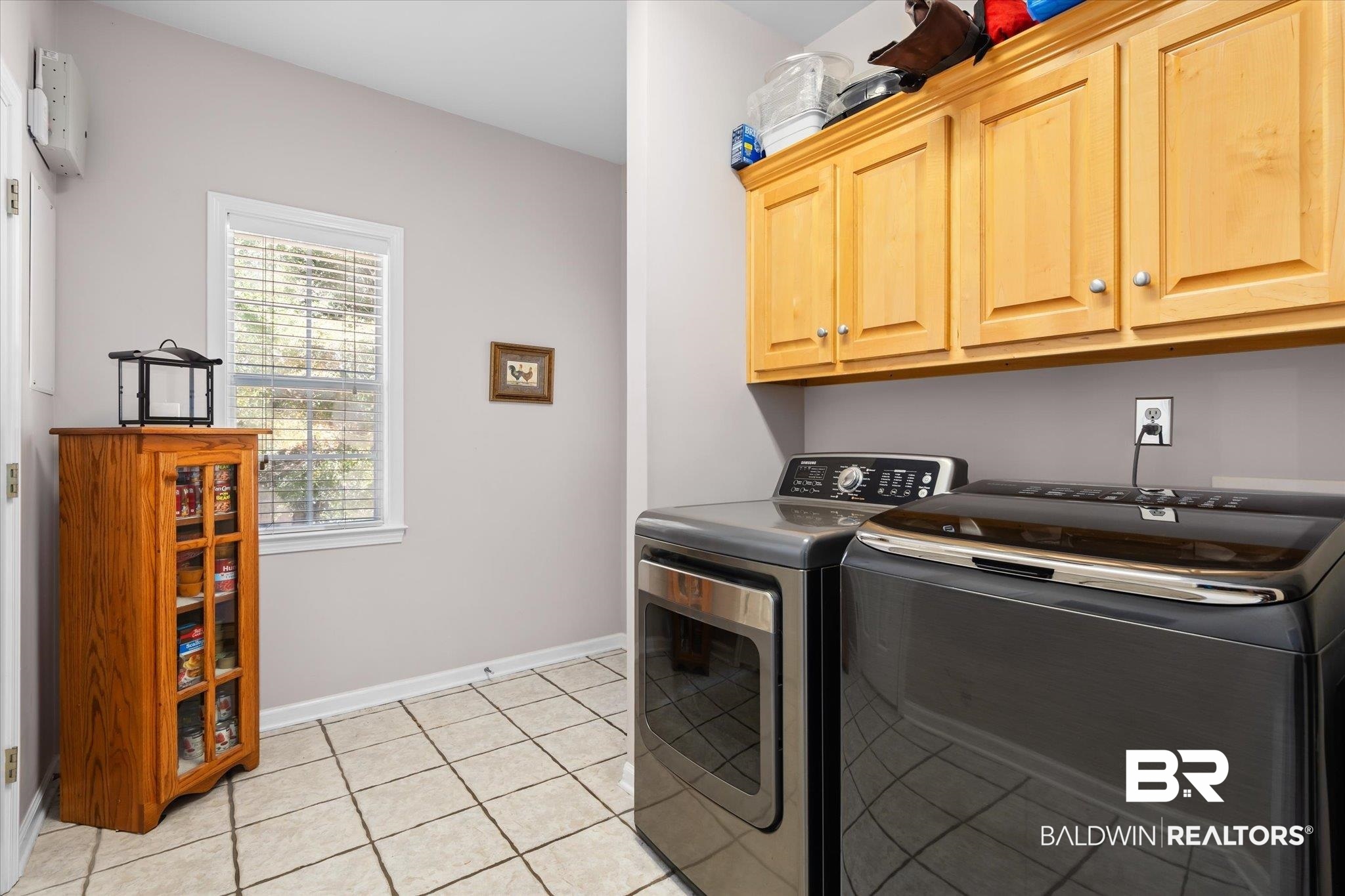 3651 Ching Dairy Loop Road South Mobile, AL 36618 - Photo 24 of 56 Laundry room with light tile patterned flooring, washing machine and clothes dryer, enclosed ironing board, and cabinets