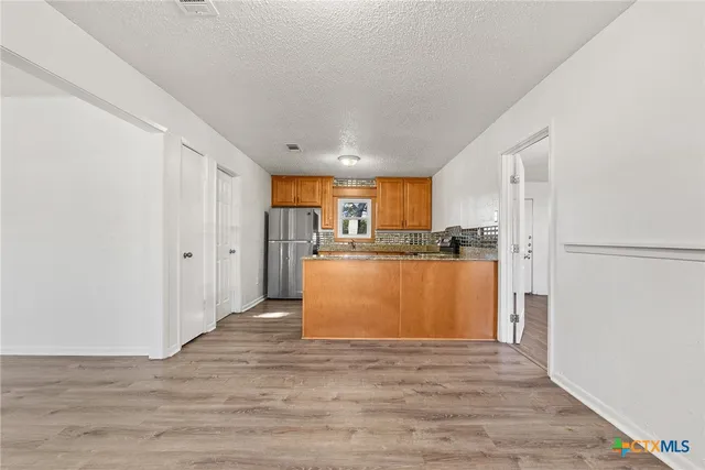 a view of kitchen with refrigerator and window