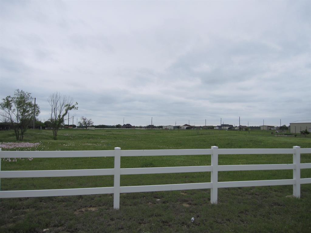 a view of a field with houses in the background