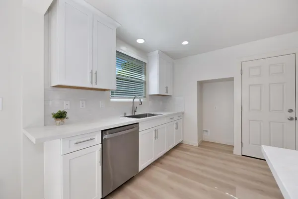 a kitchen with granite countertop white cabinets and white appliances