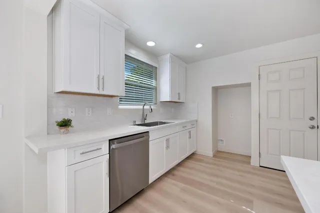 a kitchen with granite countertop white cabinets and white appliances