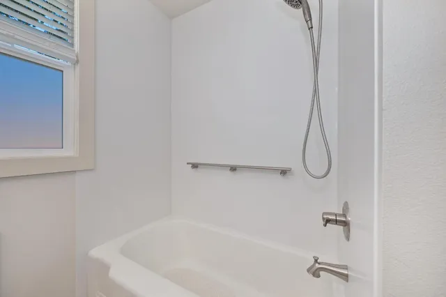 an empty room with windows and ceiling fan