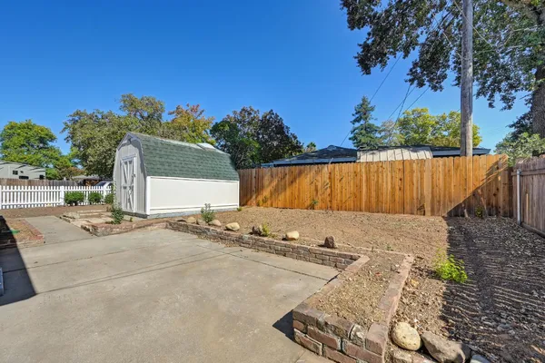 a view of small yard with wooden fence