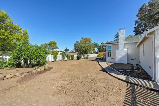 a view of a house with backyard and a tree