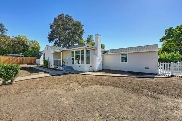 a view of a house with backyard and sitting area
