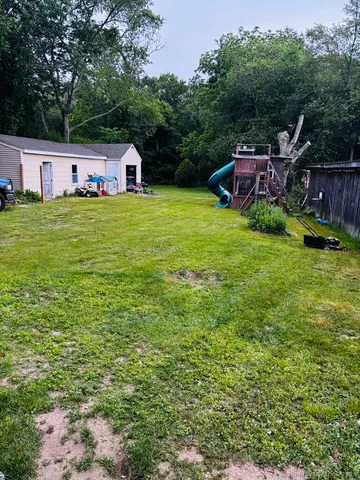 a view of a house with a yard and sitting area
