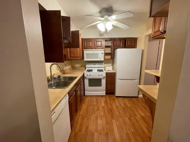 a kitchen with stainless steel appliances a refrigerator a sink a stove and white cabinets