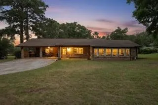 a view of a house with backyard and a tree