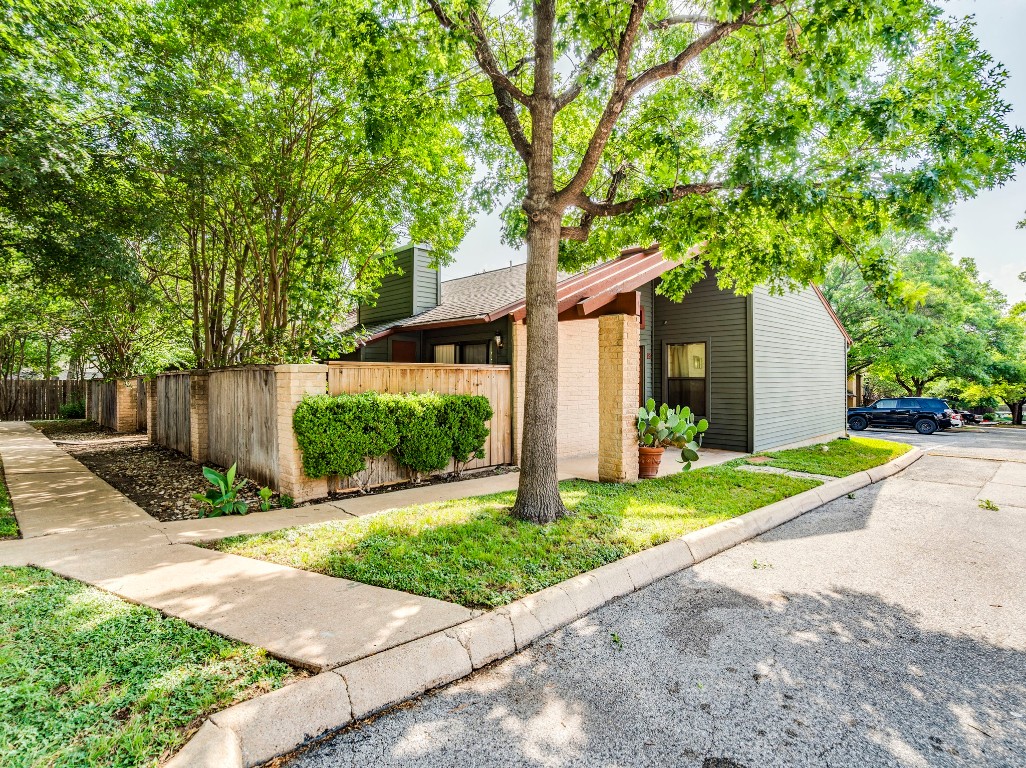 a front view of a house with a yard and potted plants