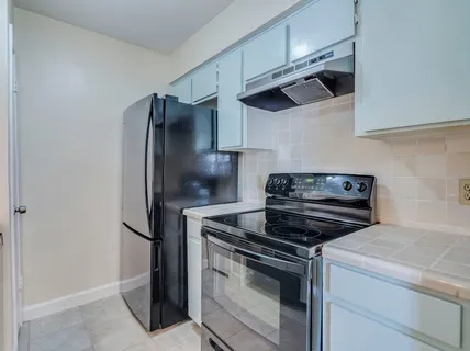 a kitchen with stainless steel appliances and white cabinets