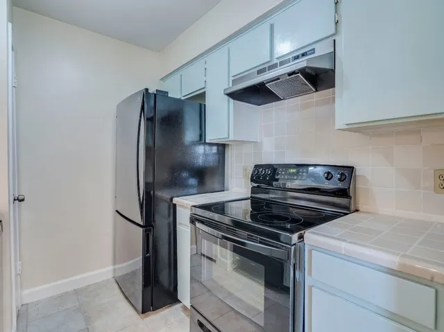 a kitchen with stainless steel appliances and white cabinets